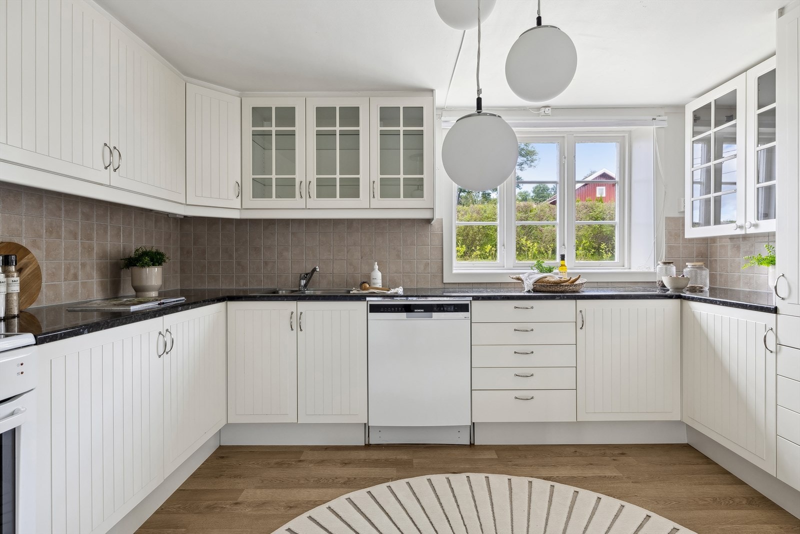 Tidløst og innholdsrikt kjøkken i u-form med hvit profilert kjøkkeninnredning og laminat benkeplate, nytt i 2007 med hvitevarer. Galleribilde