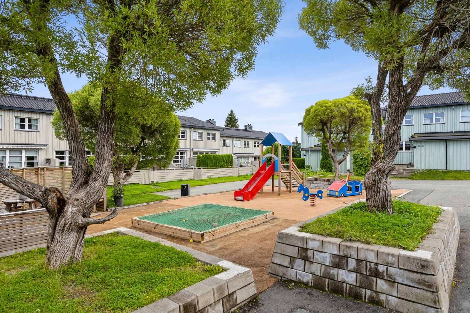 Flotte uteområde opparbeidet med benker, lekeplass og grøntareal. Galleribilde