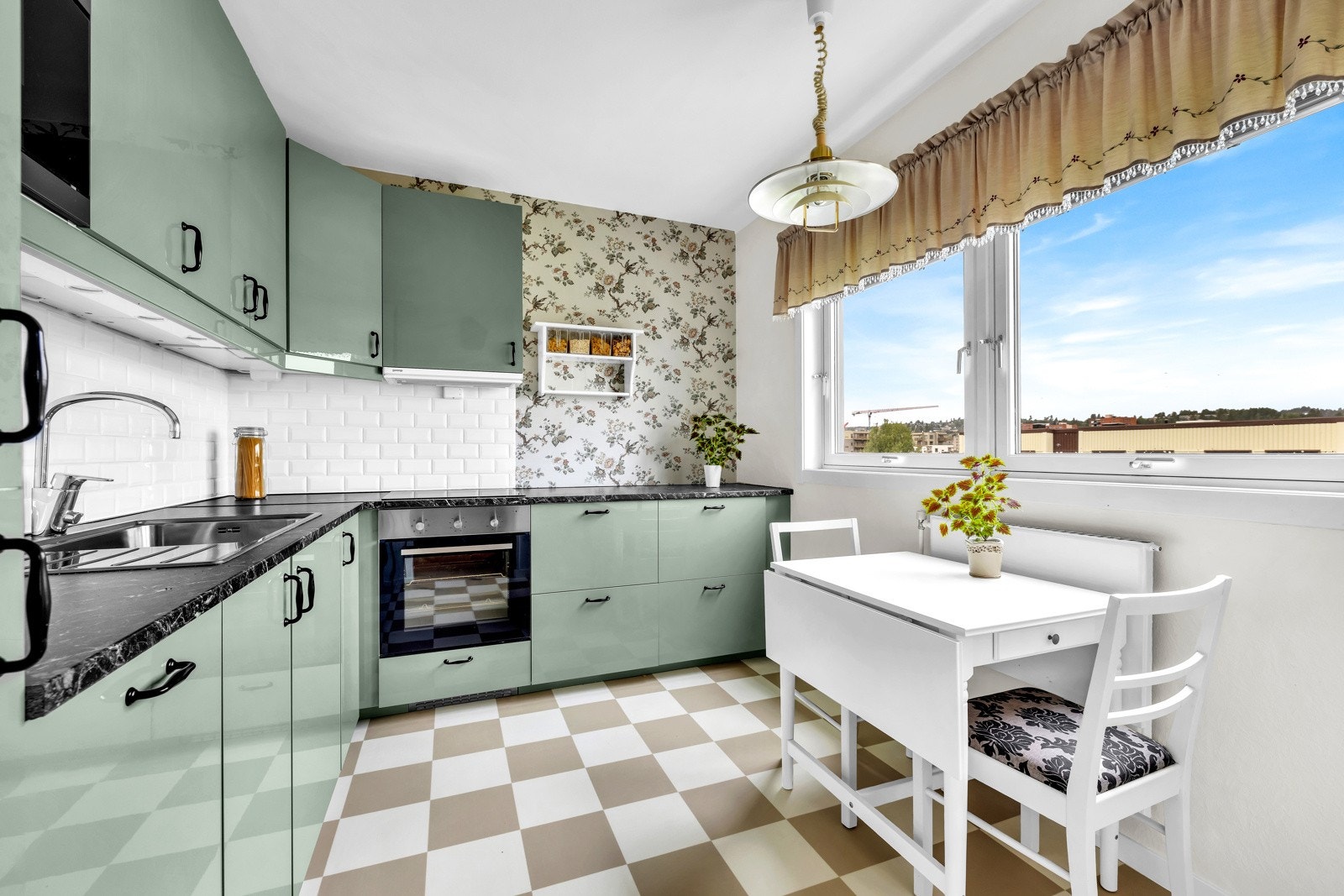 Kjøkkenet fra 2017 er moderne og stilrent. Legg merke til den tapetserte veggen og det stilige gulvet som gir rommet et eget særpreg. Galleribilde