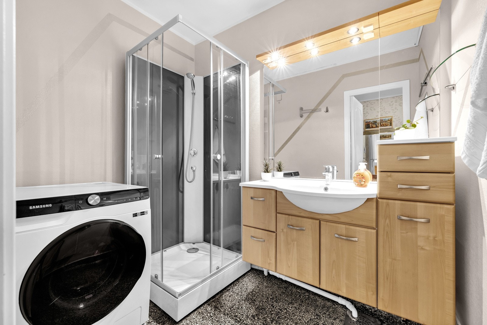 Stort baderom som ble delvis overflaterehabilitert i 2005. Badet inneholder servant med ett-greps armatur, dusjkabinett og opplegg for vaskemaskin. Galleribilde