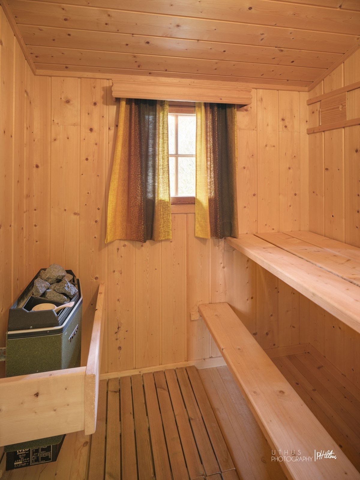 Badstuen er innredet med faste sittebenker og en elektrisk badstueovn. Galleribilde