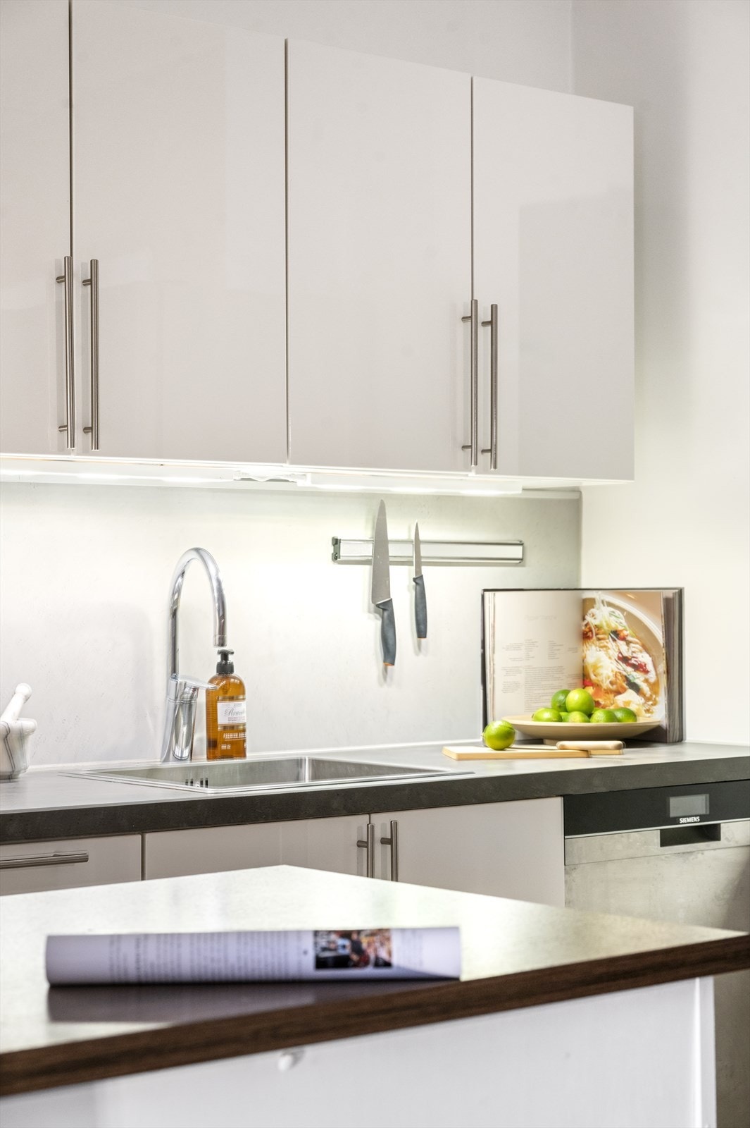 Frittstående hvitevarer med kjøleskap, komfyr og oppvaskmaskin medfølger. Det er også godt med belysning samt stikkontakter mellom benk og overskap. Galleribilde