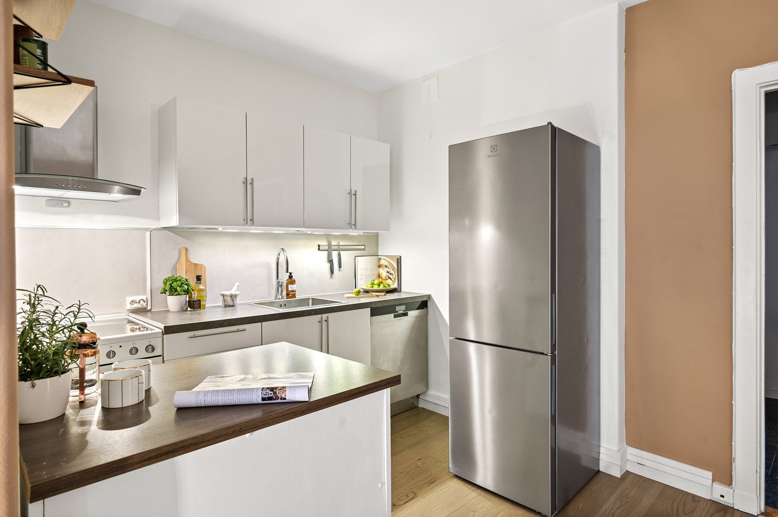 Kjøkkenet har en praktisk kjøkkenøy som gir ekstra benk- og oppbevaringsplass, men også skaper et fint skille mot stuen. Galleribilde