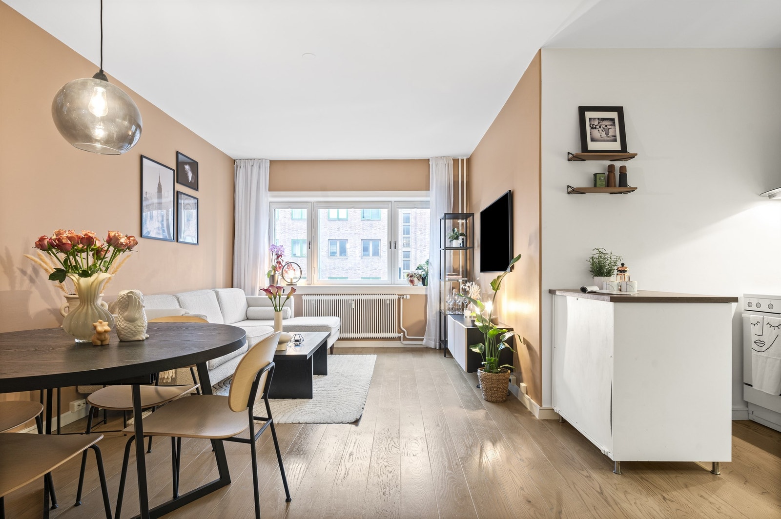 Leilighetens lyse og stilsikre kjøkken er holdt i en åpen løsning mot stuen. En slik type kjøkkenløsning/utforming tilfredsstiller mange behov - for deg som ønsker mye benk- og skapplass og for deg som ønsker et åpent og sosialt rom Galleribilde