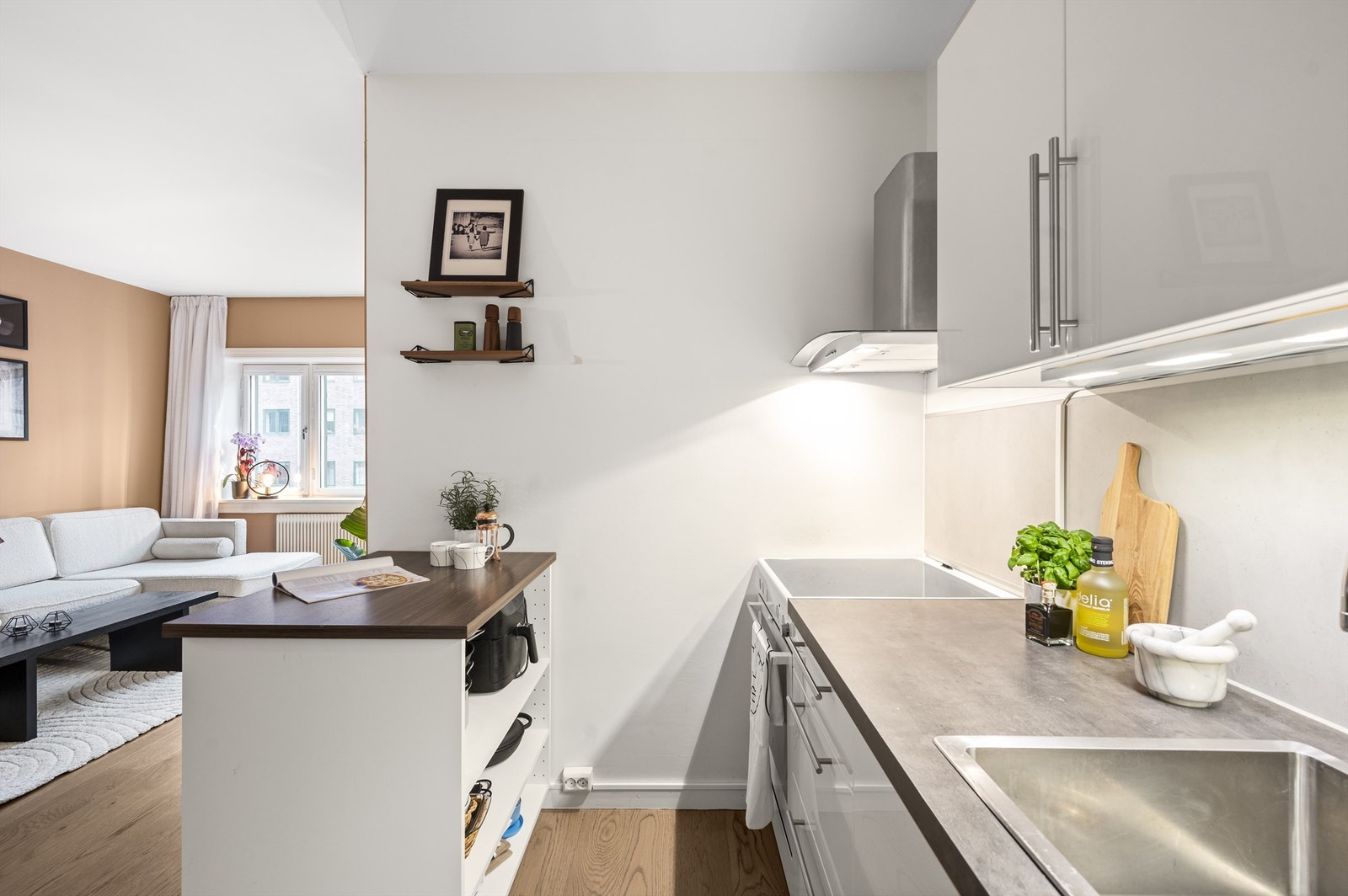 Innredningen består av hvite glatte fronter, benkeplate i laminat, nedfelt oppvaskkum og ett-greps armatur. Innredningen er tilpasset rommets utforming for en god bruk av stue- kjøkkenområdet. Galleribilde