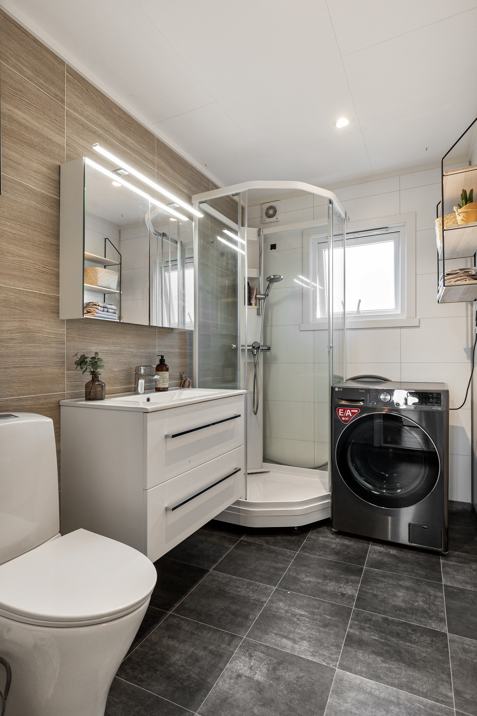 Deliakt baderom bestående av servant med underskuffer, gulvstående toalett og dusjkabinettt Galleribilde