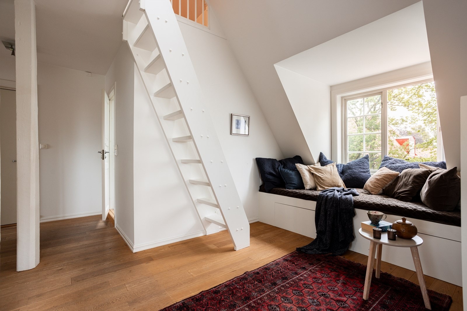 Ved vinduet er det laget en herlig sitteplass og det er trapp opp til hemsløsningen. Galleribilde