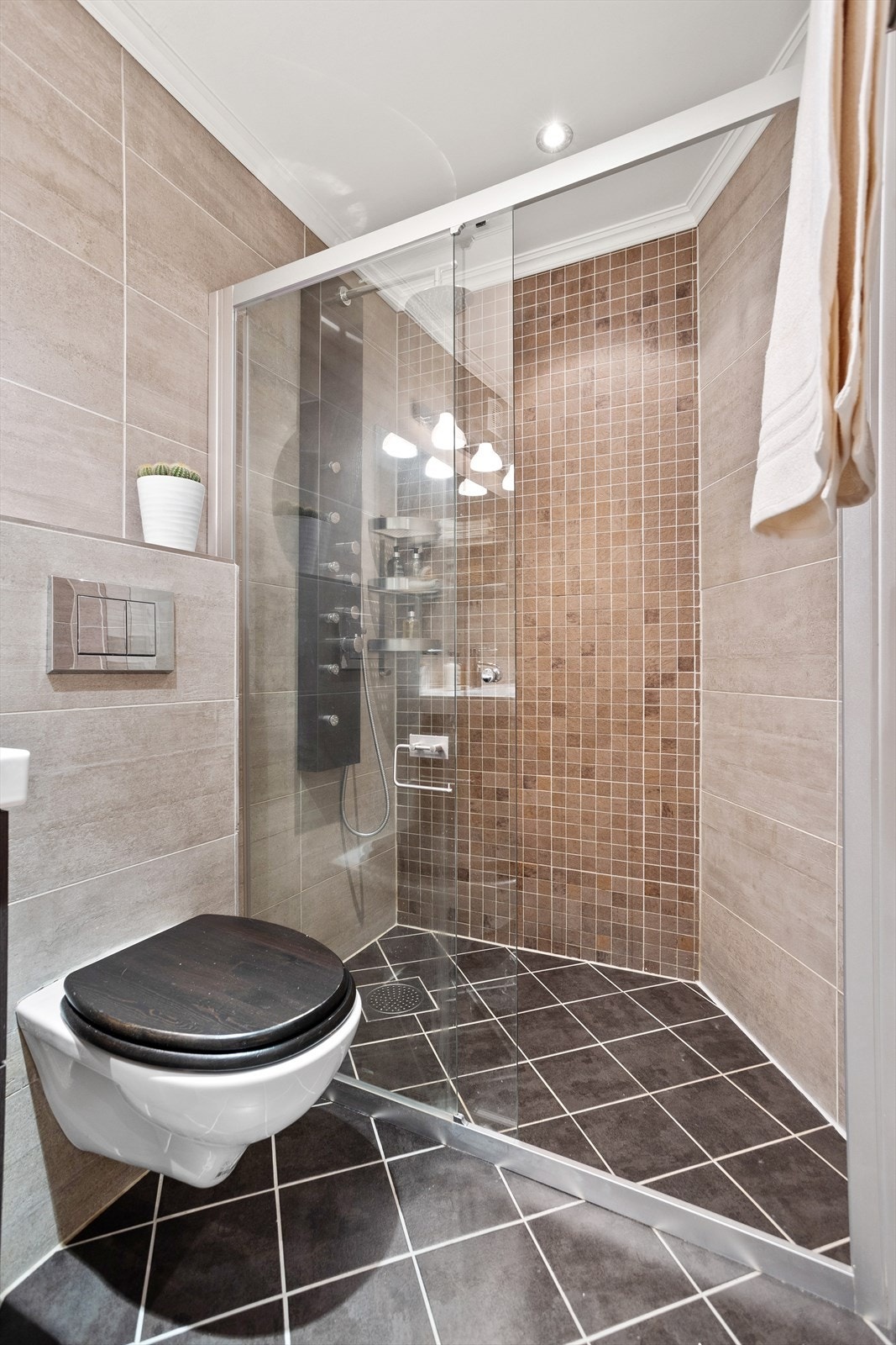 Badet er av god størrelse med plass til både dusj, servant med underskap og vaskemaskin Galleribilde