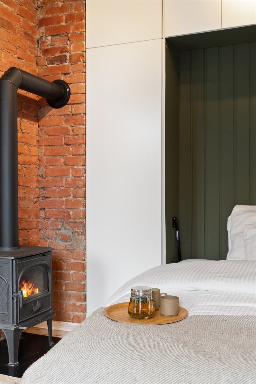 Her kan du ligge og nyte lange søndagsmorgener i sengen med peisen rett ved siden av Galleribilde