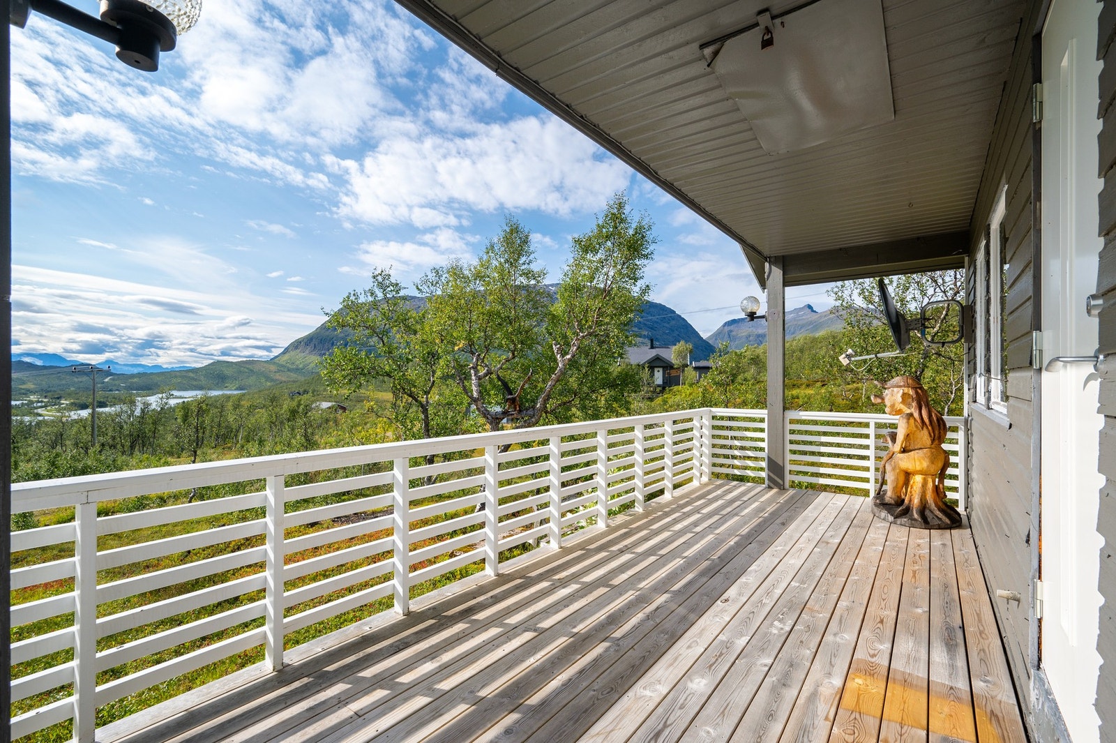 Fra verandaen kan du nyte fine dager i hytteveggen med utsikt til fjell og natur Galleribilde
