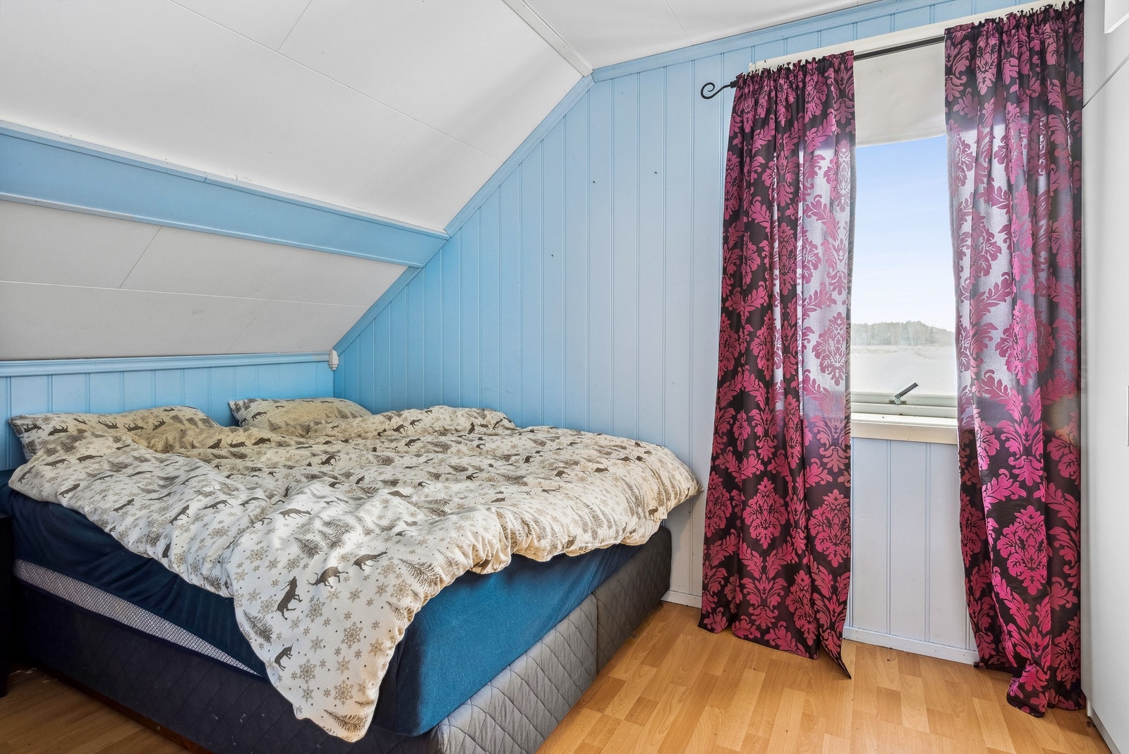Det er to soverom i boligen, begge ligger i 2. etasje. Ett soverom med lysblå malt panel på veggene og laminat på gulvet. Rommet er etablert med garderobeskap og har god plass til annet soveromsmøblement. Galleribilde