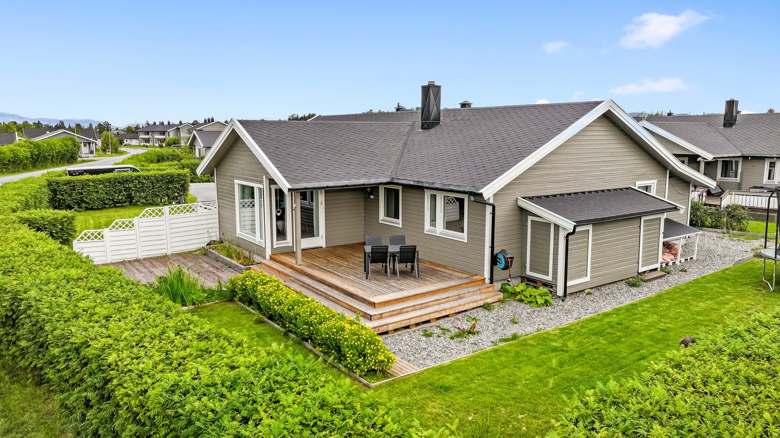 Det er en velstelt hage. Utebod på kortvegg. Galleribilde