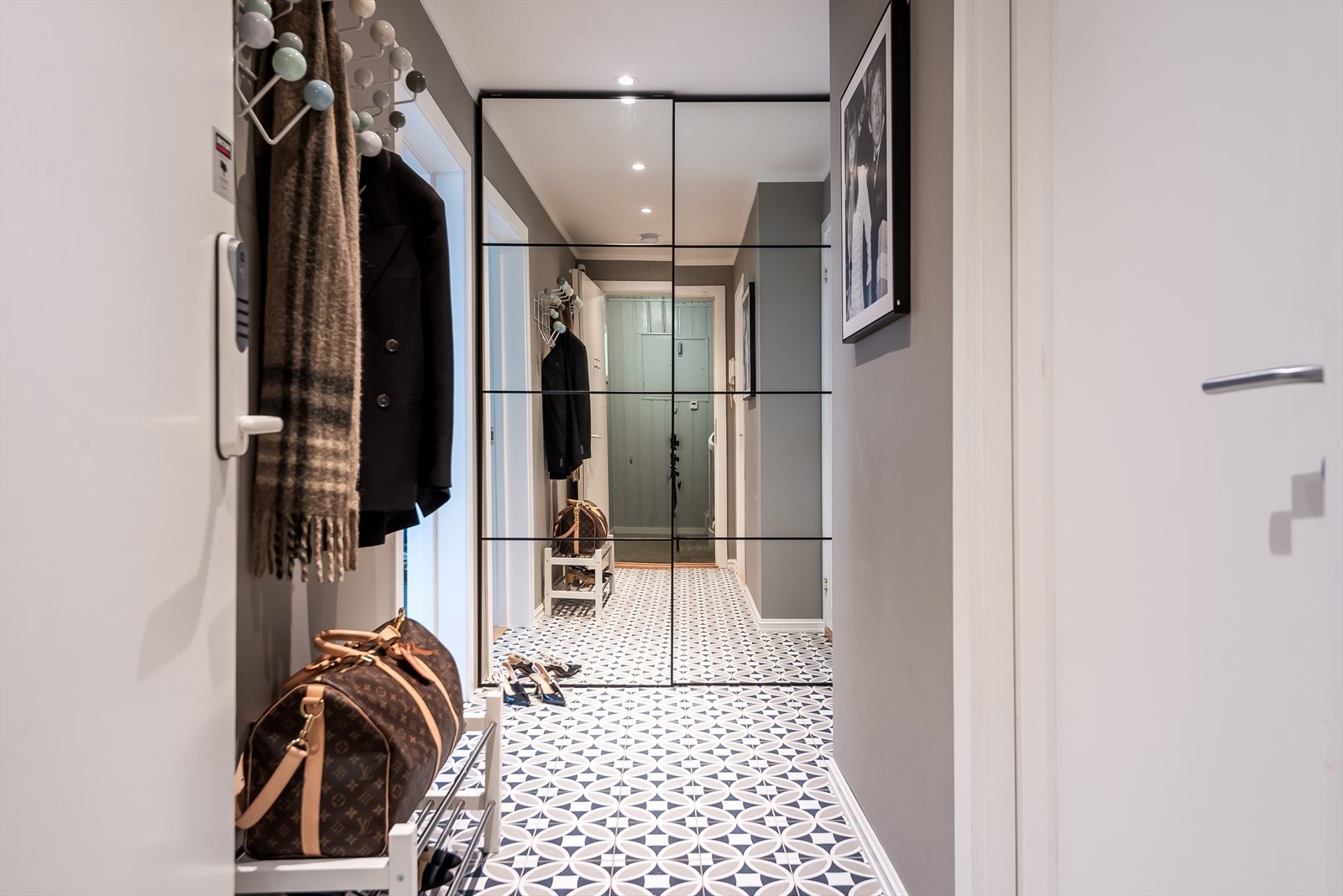 Inngangspartiet gir et flott førsteinntrykk av boligen med moderne fliser og et stort garderobeskap med dobbelspeil, det er også varmekabler i gulv Galleribilde