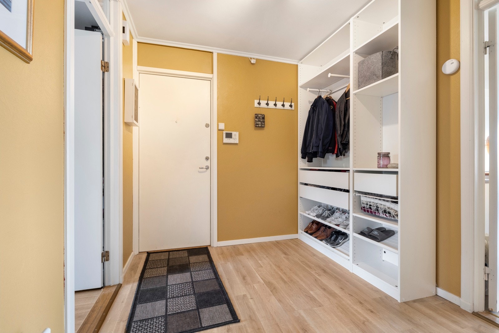 Leiligheten har en romslig entré med knaggrekke og åpen garderobe Galleribilde