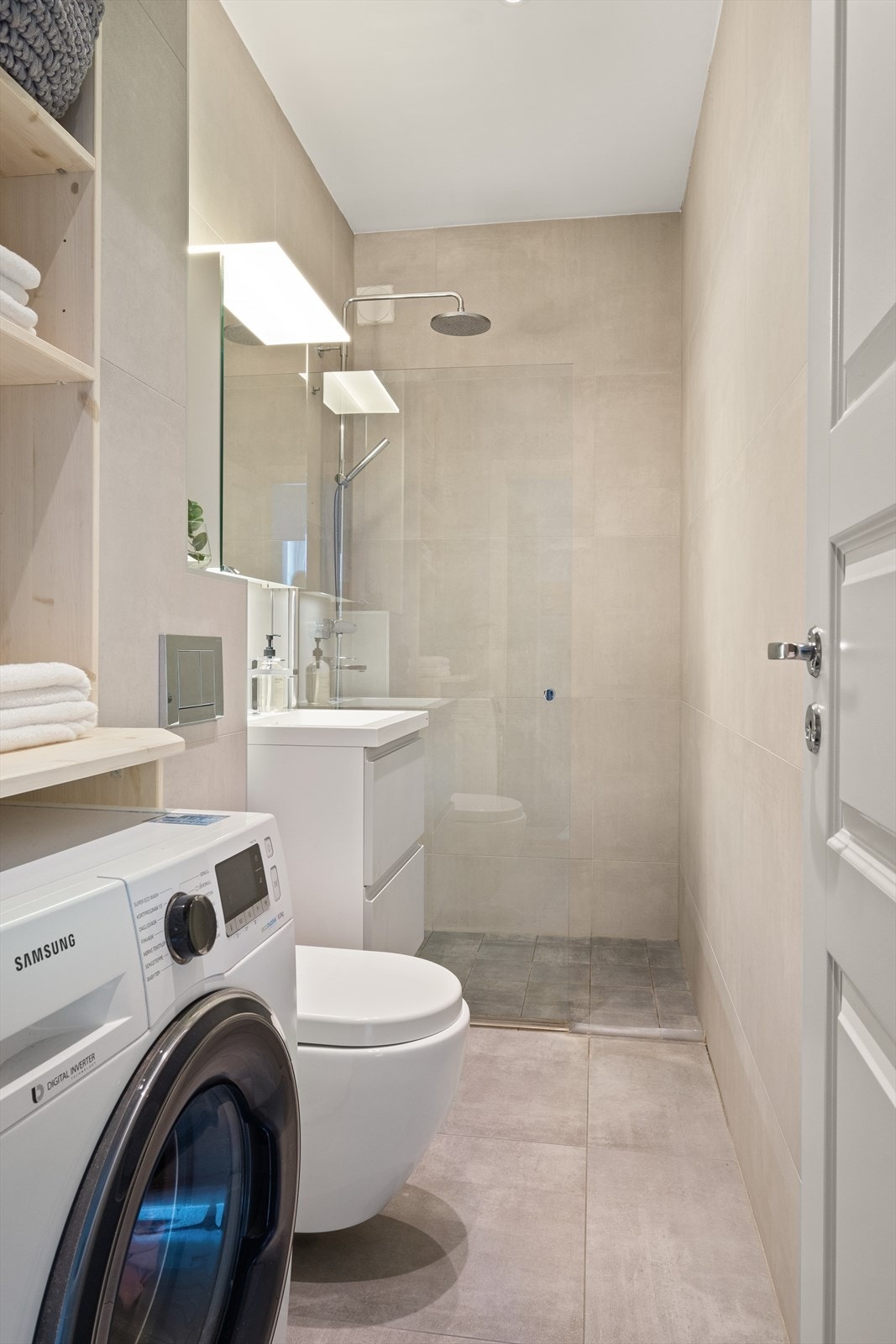 Lyst og stilrent flislagt bad med downlights i himling og varmekabler i gulv. Galleribilde