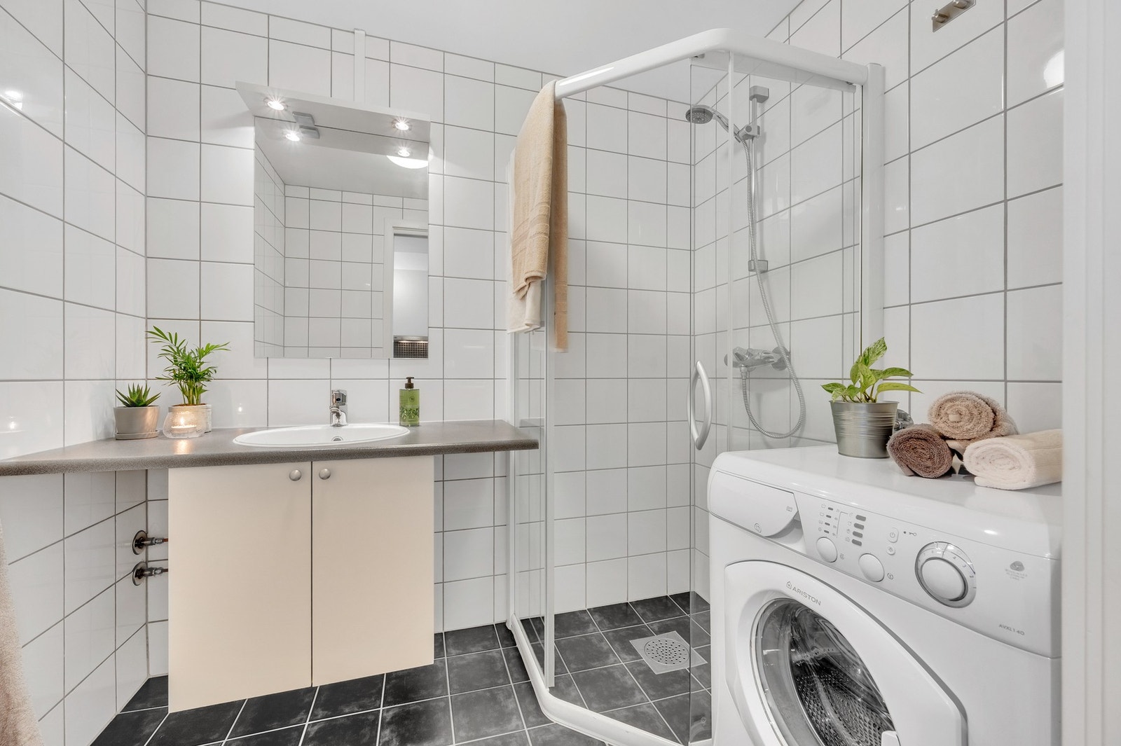 Lyst og pent baderom med opplegg for vaskemaskin. Galleribilde