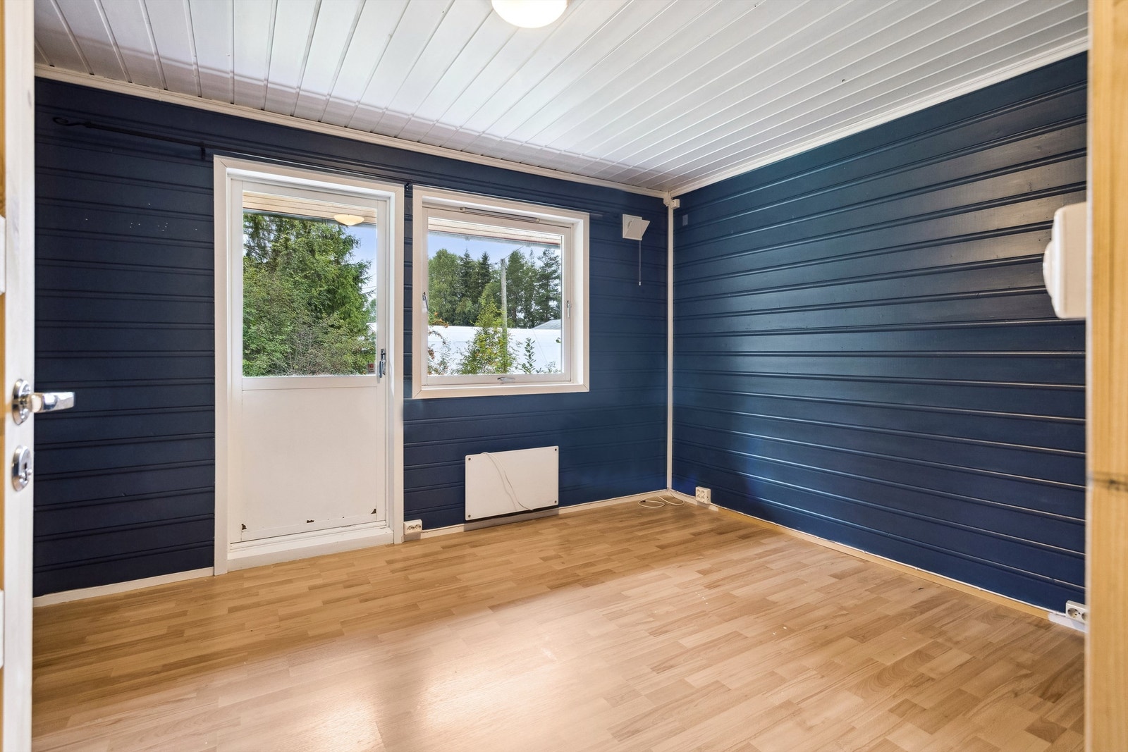 Det er tre soverom i boligen, og alle i hovedetasjen. Ett soverom har mørkblå malt panel på veggene og lys laminat på gulvet. Galleribilde