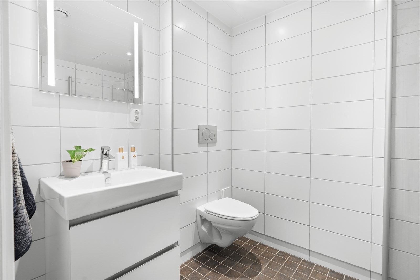 Videre er rommet innredet med dusj, veggfestet klosett og servant. I tillegg har badet opplegg for vaskemaskin. Galleribilde