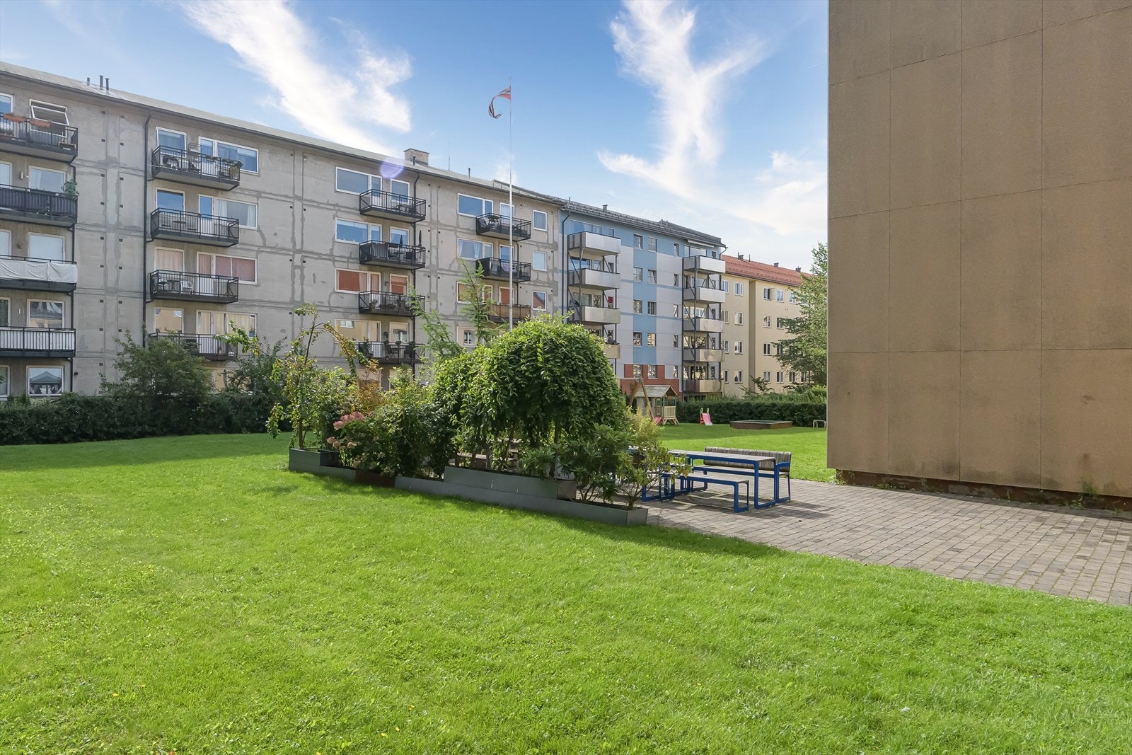 Hyggelig fellesareal med flotte grøntområder og flere sittegrupper. Galleribilde