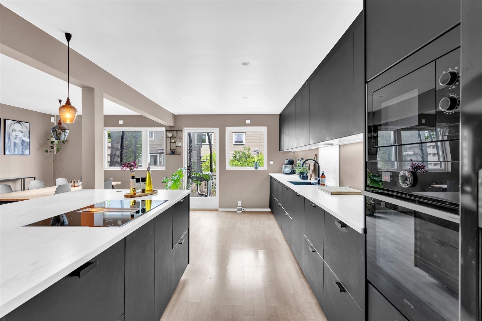 På kjøkkenøyen er det platetopp med integrert ventilator for et renere uttrykk. Her kan man være sosial med alle gjester under matlagingen. Galleribilde