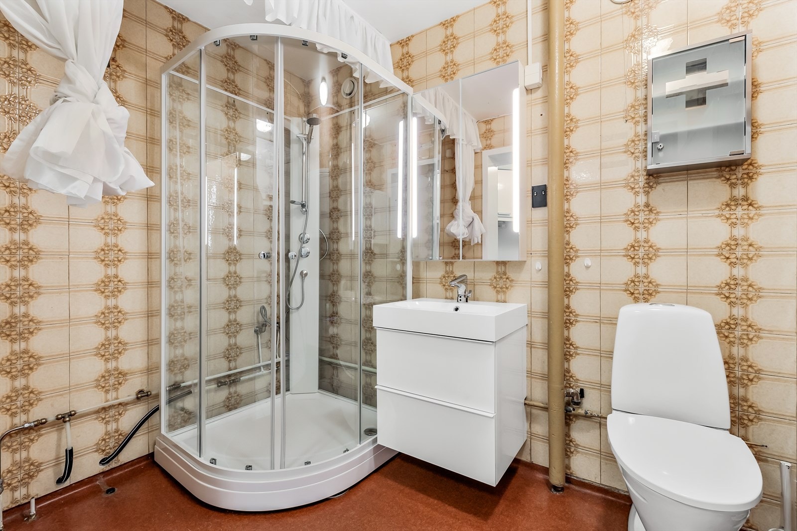 Innredningen i badet består av enkel servant med speil og dusjkabinett. Galleribilde