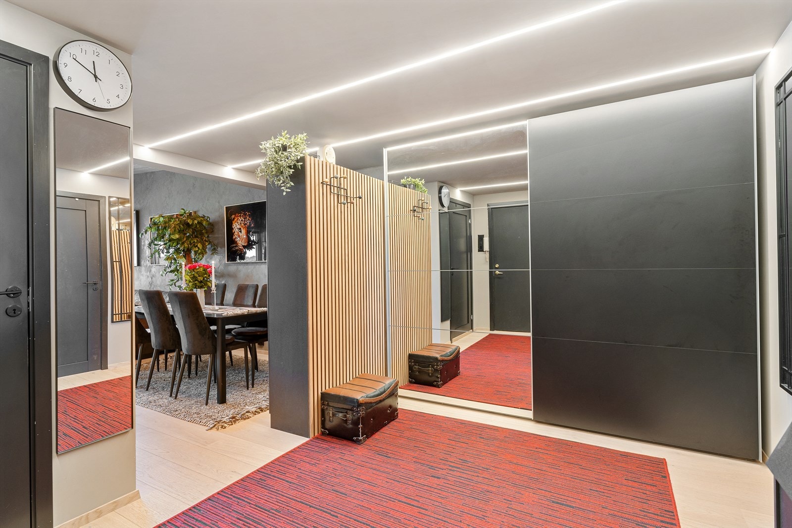Romslig entré/gang som er innredet med skyvedørsgarderobe Galleribilde