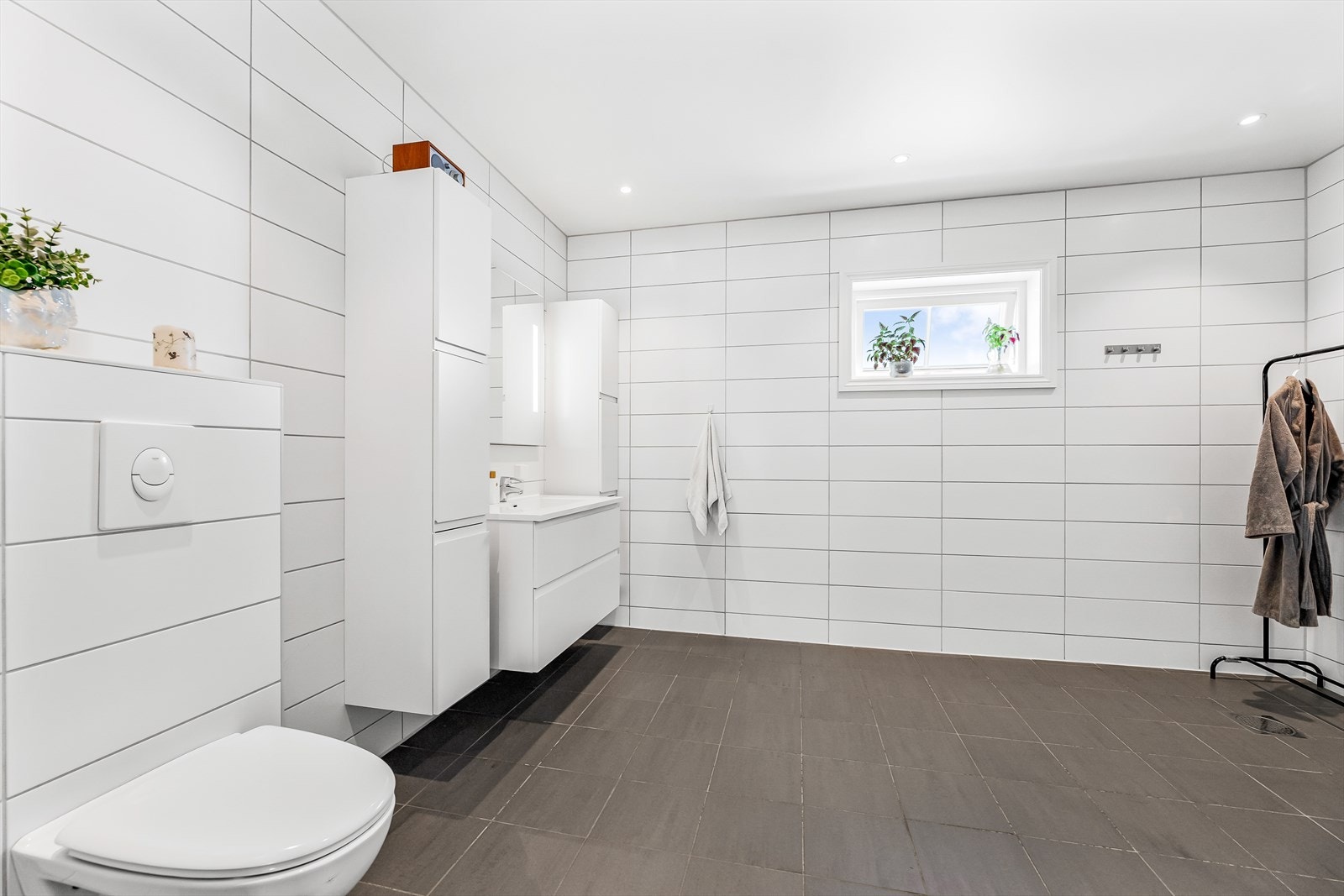 Badet i 2.etasje har flislagte overflater fra 2021. Veggfestet klosett med innebygget sistern og servant. Galleribilde