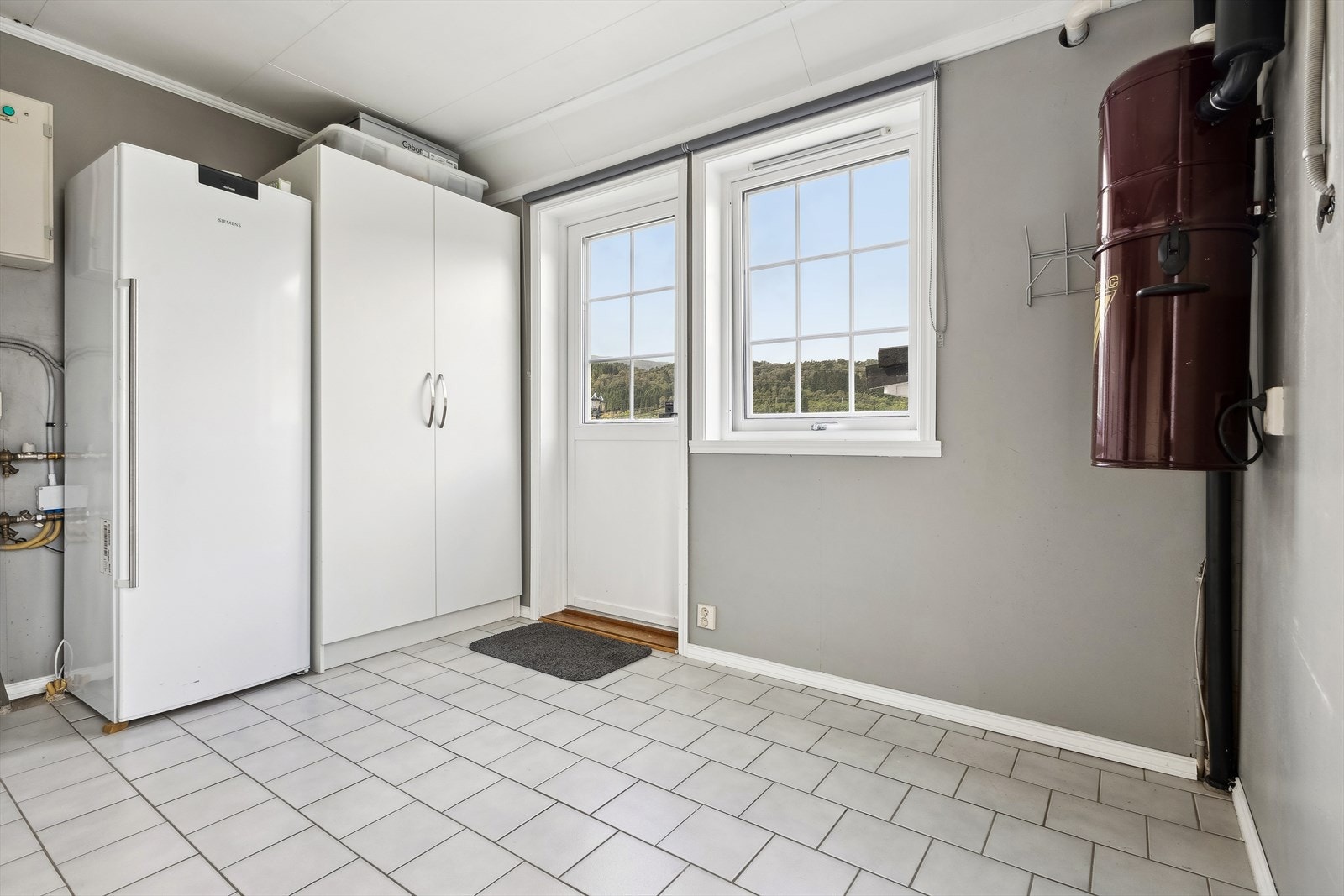 Teknisk rom / romslig bod med utgangsdør til hage. Det er vannboren varme i alle gulv i 1.etasje Galleribilde