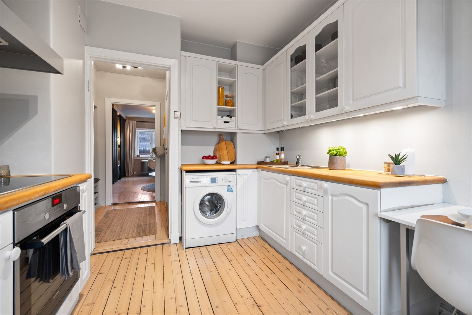 Kjøkkenet er innredet med profilerte fronter, laminert benkeplate, nedfelt kum i rusfritt stål, stekeovn og induksjonstopp. Det er god plass til frittstående kjøleskap/frys og opplegg for vaskemaskin Galleribilde