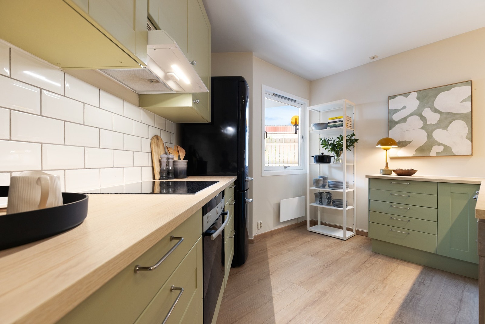 Kjøkkeninnredningen består av profilerte fronter i moderne fargevalg, laminat benkeplate og nedsenket oppvaskkum i porselen med ett-greps armatur. Galleribilde