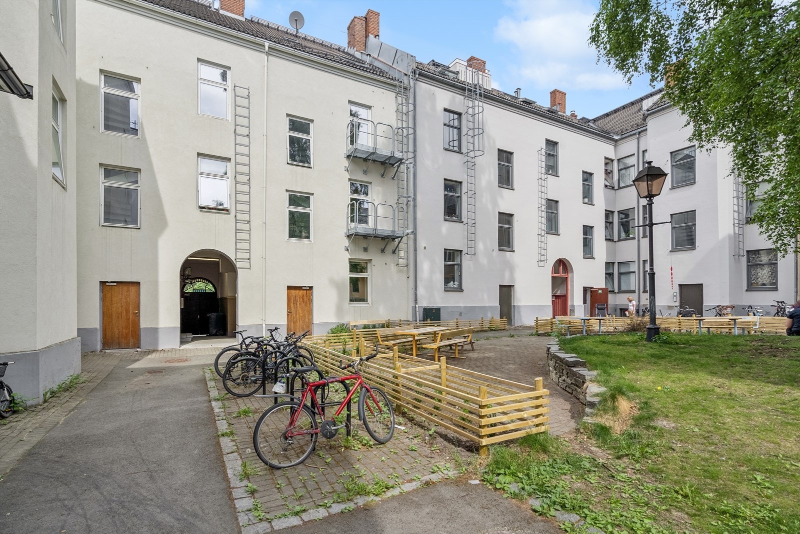 Fasaden i bakgården ble pusset opp i 2015. Her har man grøntarealer og sitteplasser, samt sykkelparkering og en liten lekeplass. Galleribilde