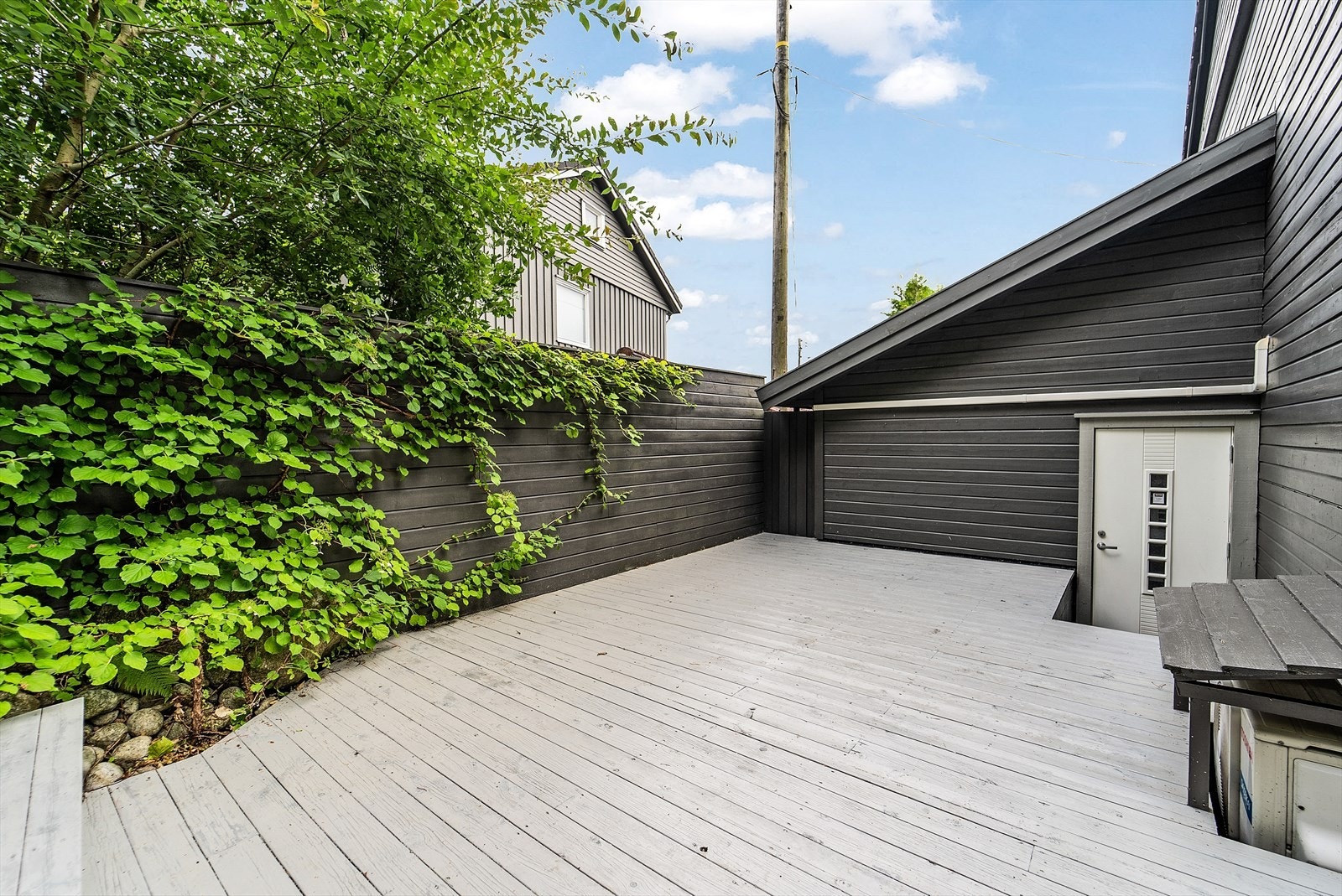 Usjenert terrasse bak huset med adkomst fra både garasje og soverom. Galleribilde