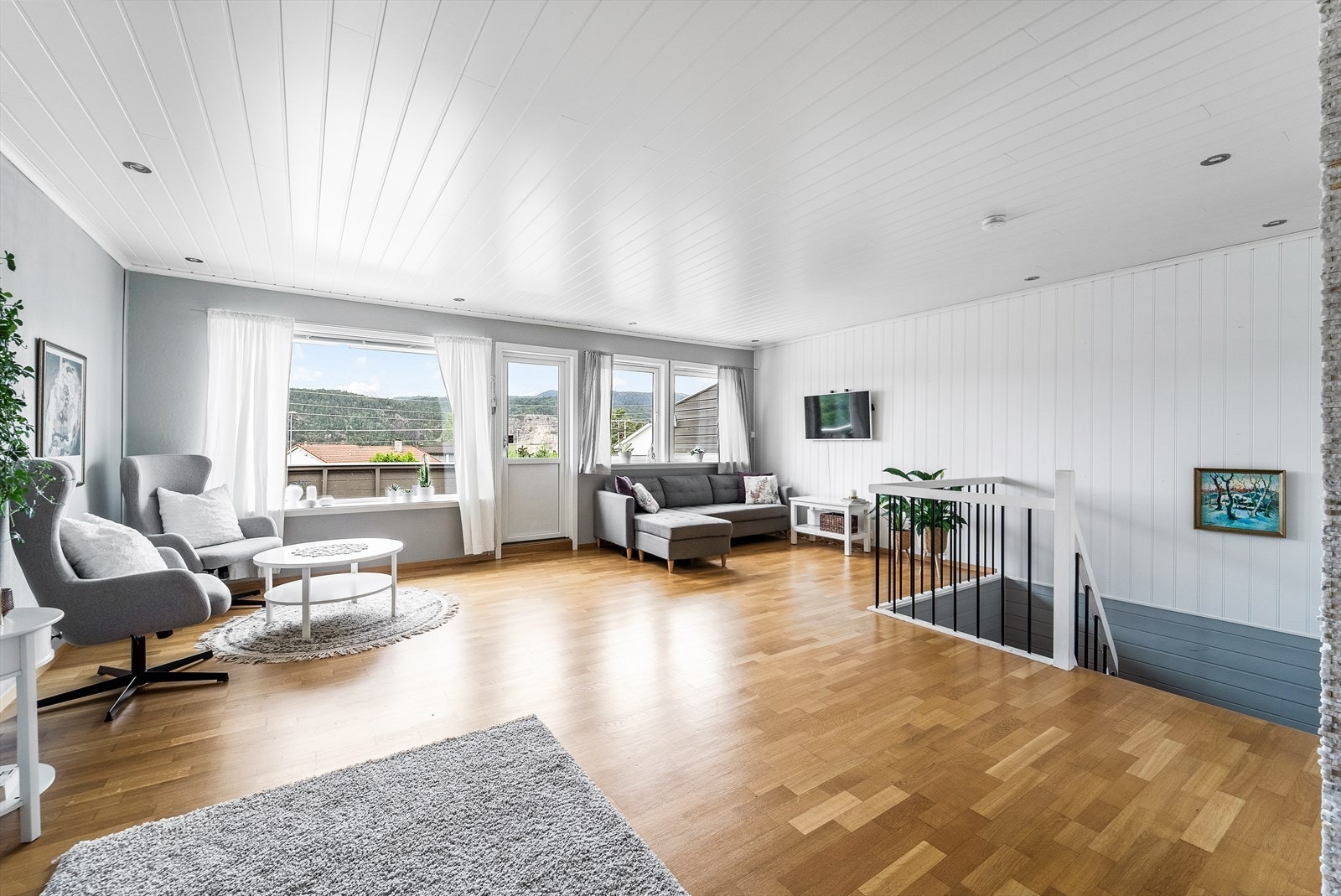 Stor stue med generøse vindusflater og innebygde spotter i tak. Galleribilde