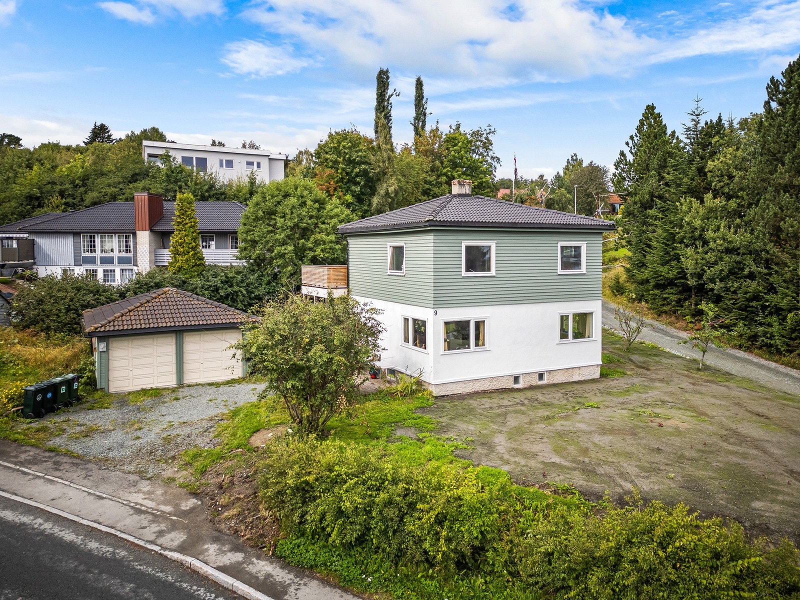 Parkering i garasje og biloppstillingsplass på egen tomt. Hagen ser slik ut etter å ha blitt planert ut, trykk videre for å se hvordan hagen blomstrer nå. Galleribilde