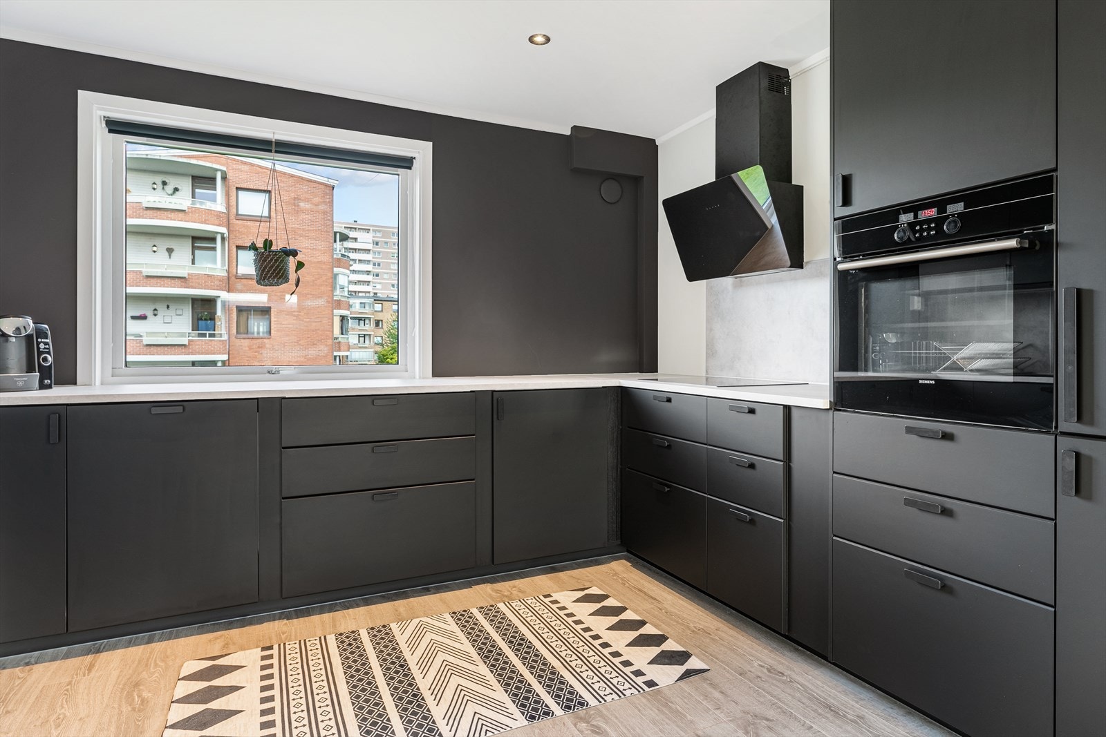 Stilig kjøkken med mye skapplass og vindu Galleribilde