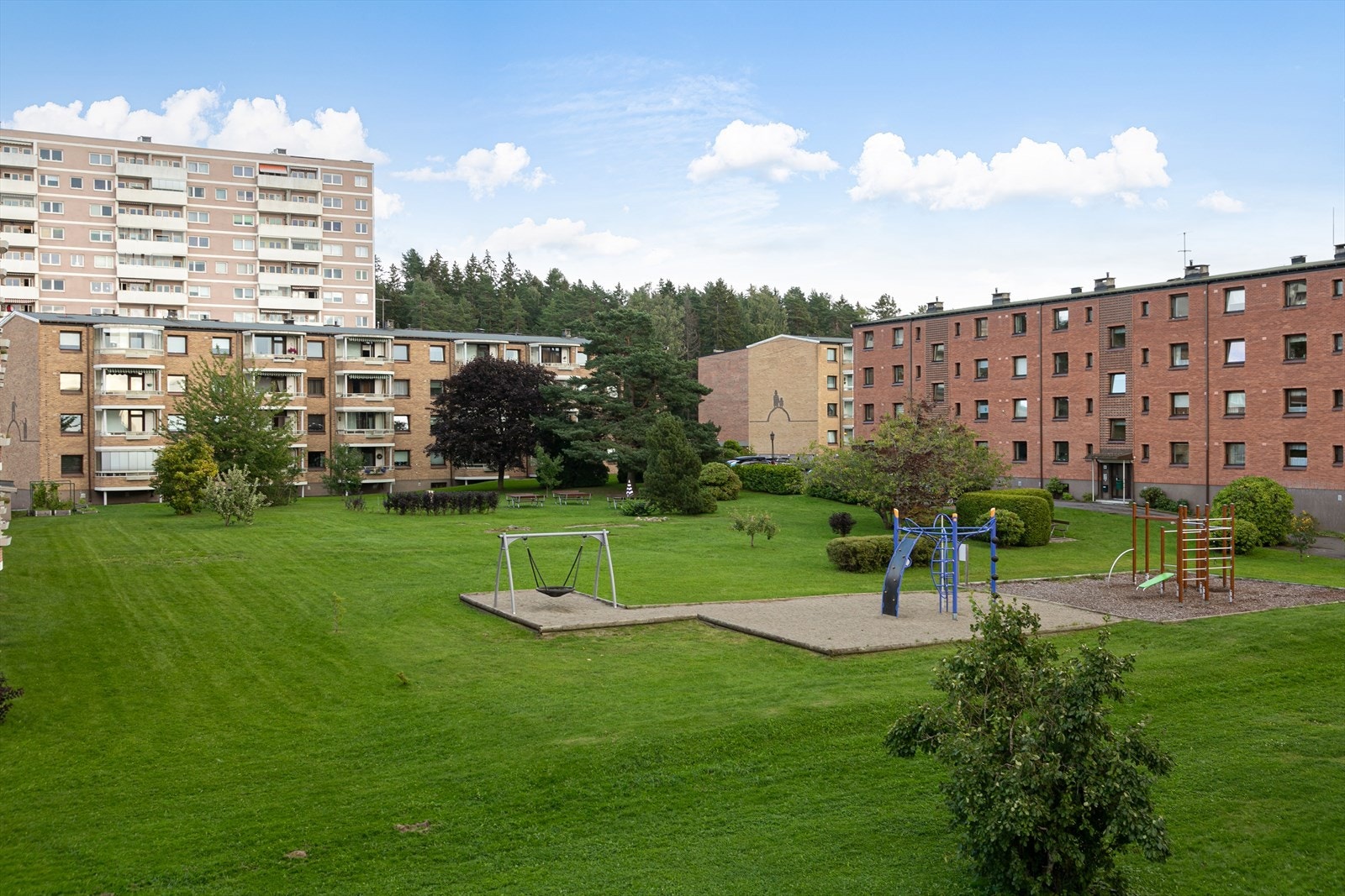 Grøntområde med lekeplass og benker Galleribilde
