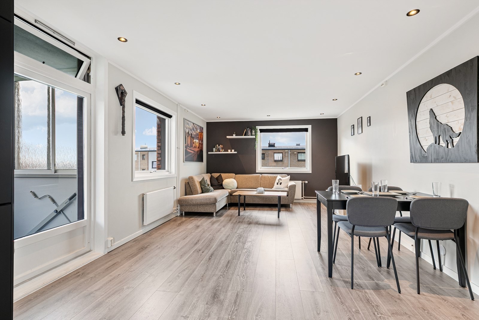 Åpen stue med spiseplass og store vinduer som slipper inn mye naturlig lys Galleribilde