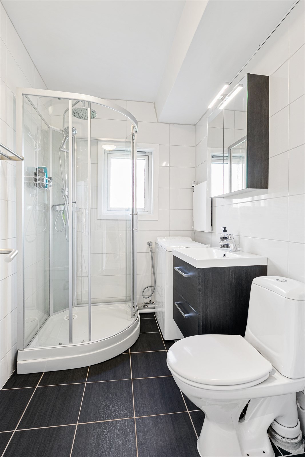 Pent bad med dusjkabinett og vaskemaskin samt varmekabler i gulv Galleribilde