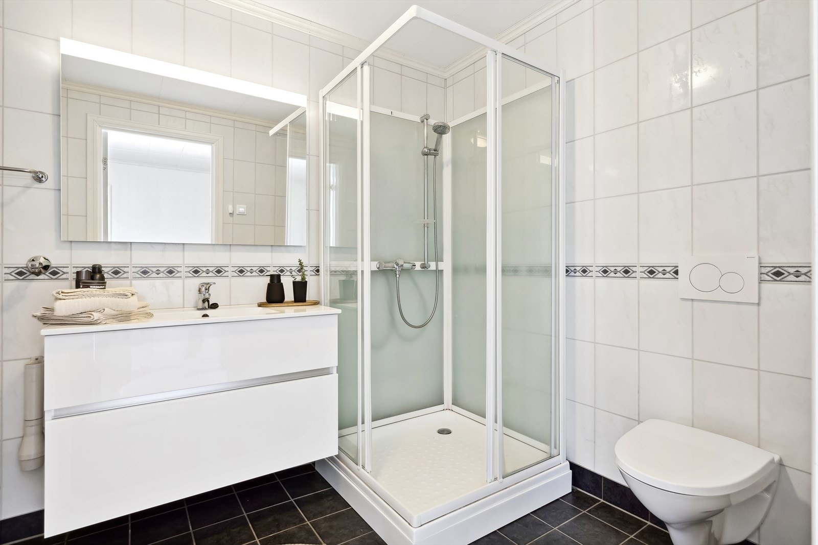 Badet i første etasje er utstyrt med toalett, dusjkabinett og innredning med god oppbevaringsplass. Galleribilde