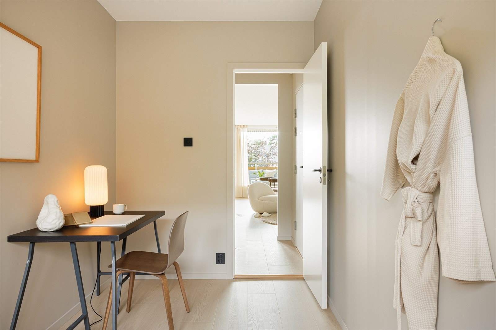 Gulvet av 1-stavs laminat er gjennomgående for boligen, og gir en sømløs overgang mellom de ulike rommene Galleribilde