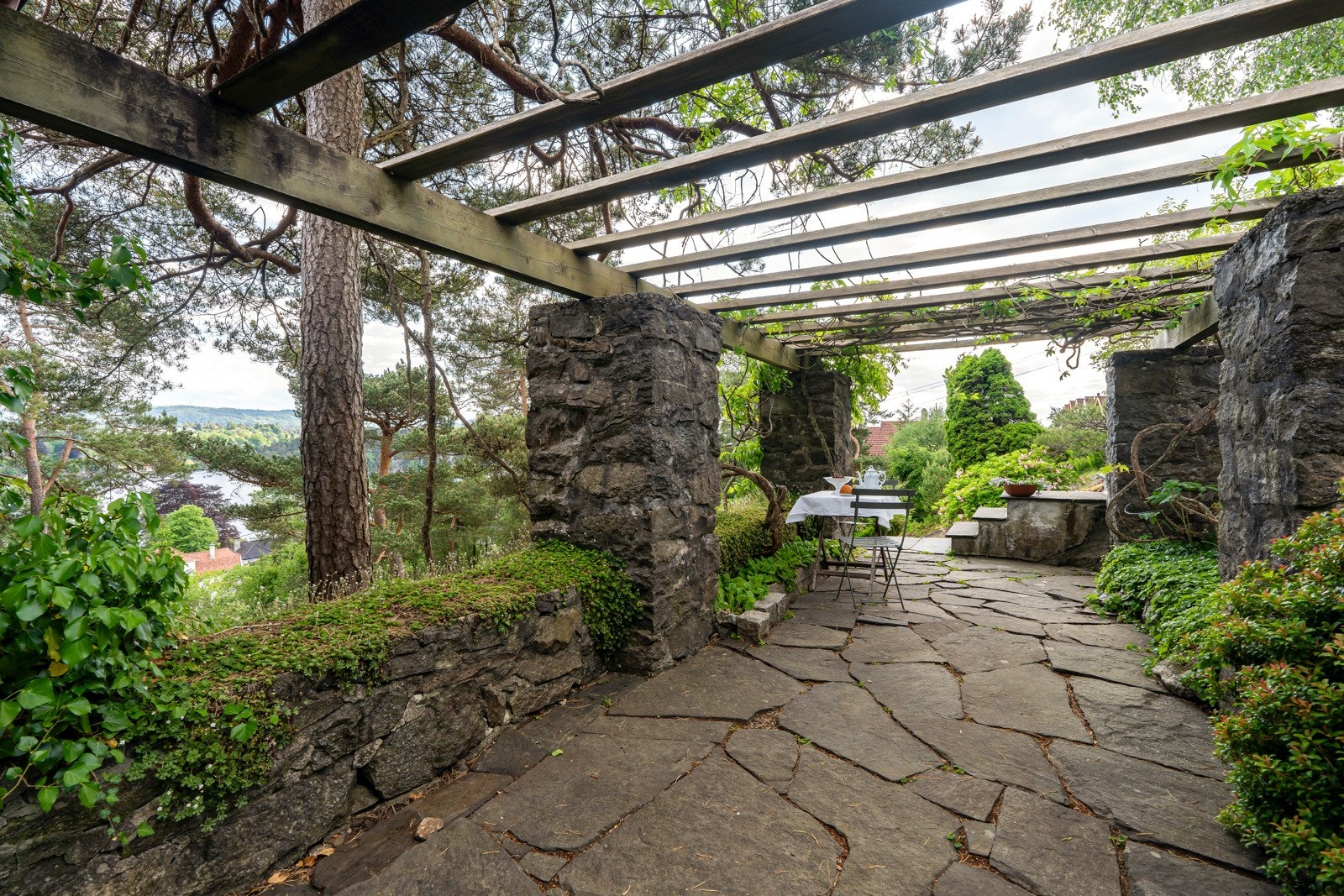 Det er plass til langbord i pergolaen. Galleribilde