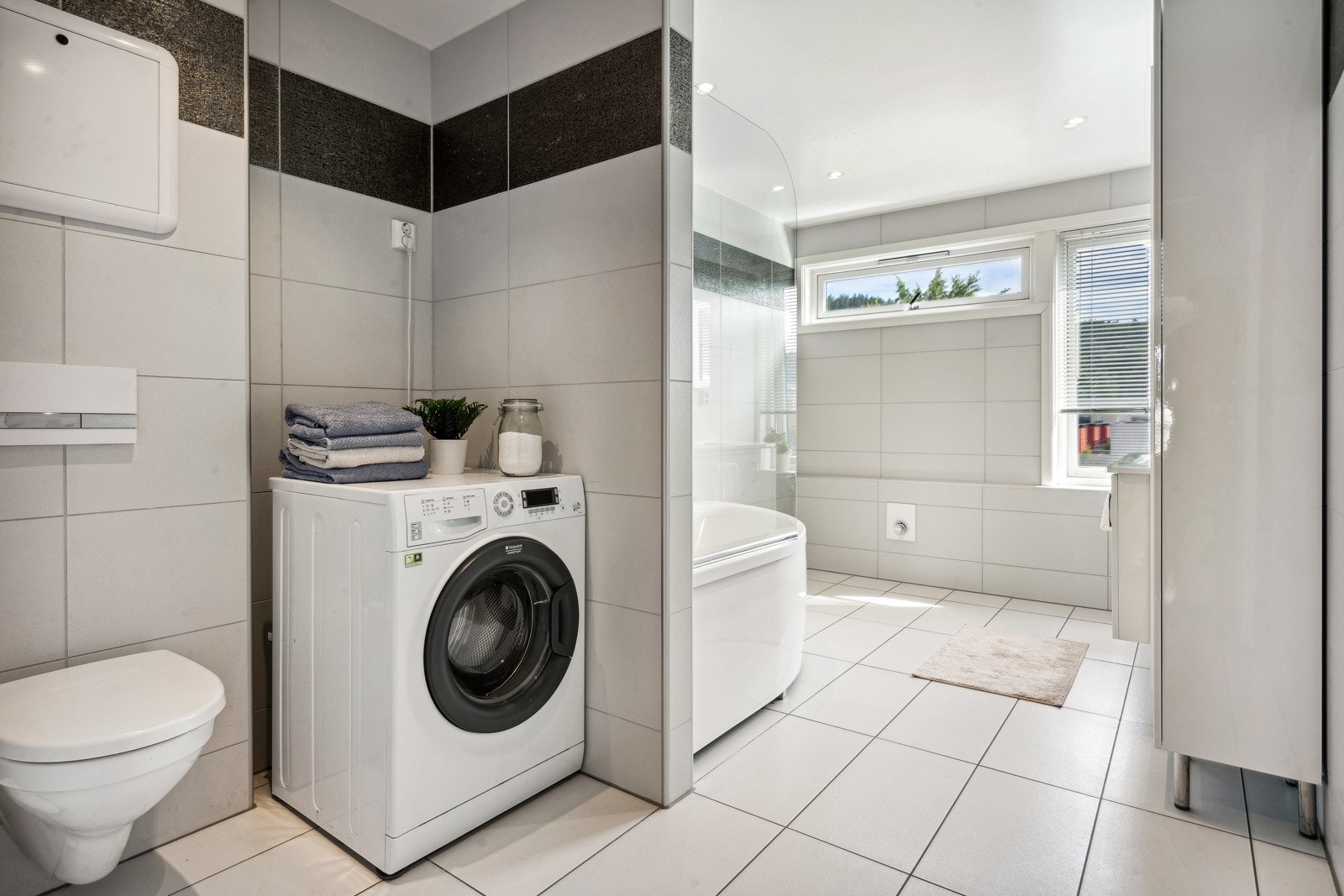 Videre er badet utstyrt med downlights, badekar, opplegg for vaskemaskin og toalett. Galleribilde