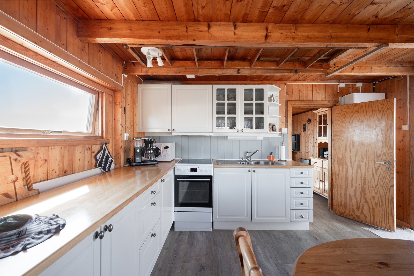 Innholdsrikt kjøkkeninnredning med romslig skap- og benekplass Galleribilde