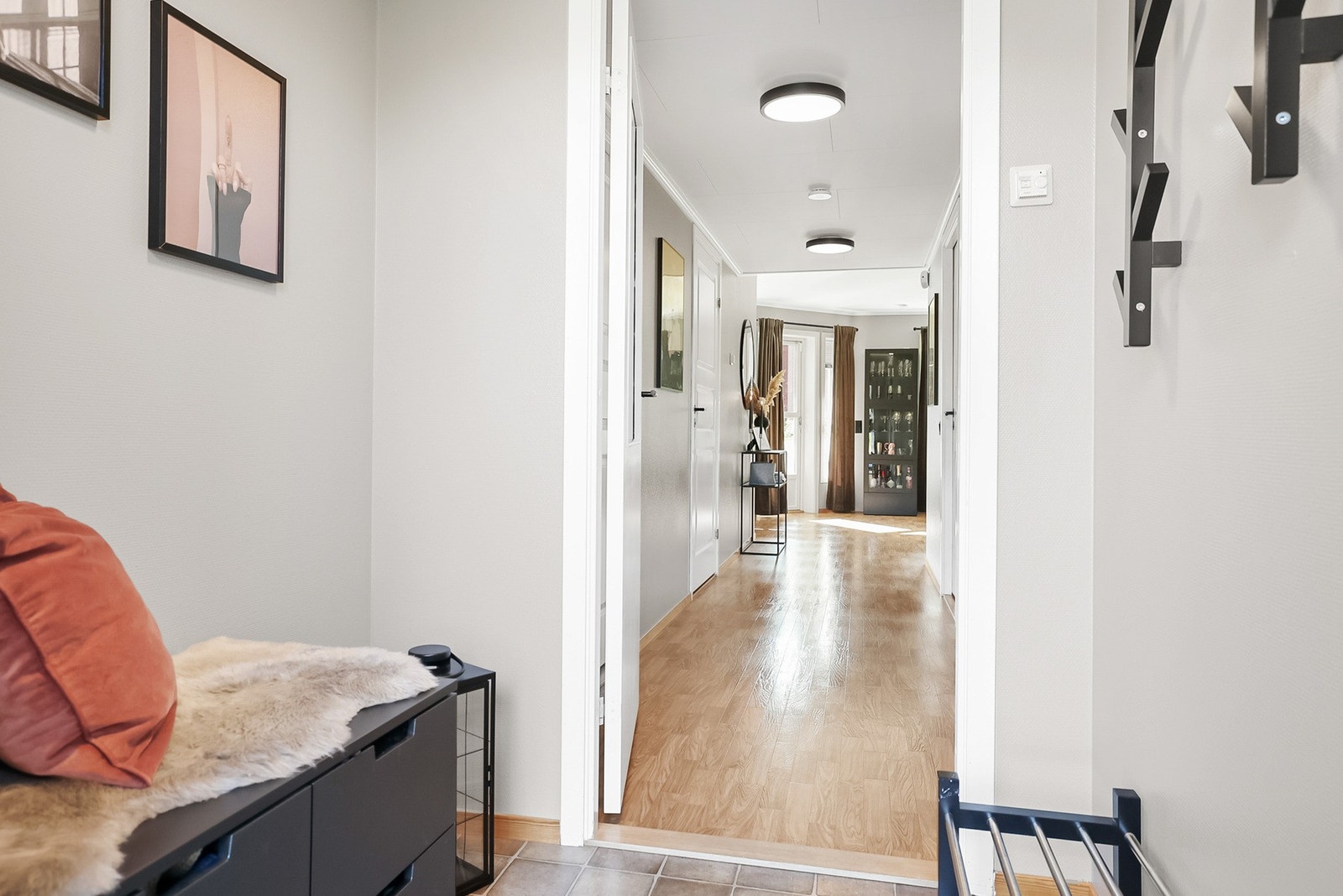 Lys og flislagt entré med plass til diverse oppbevaring i kommode eller skap Galleribilde