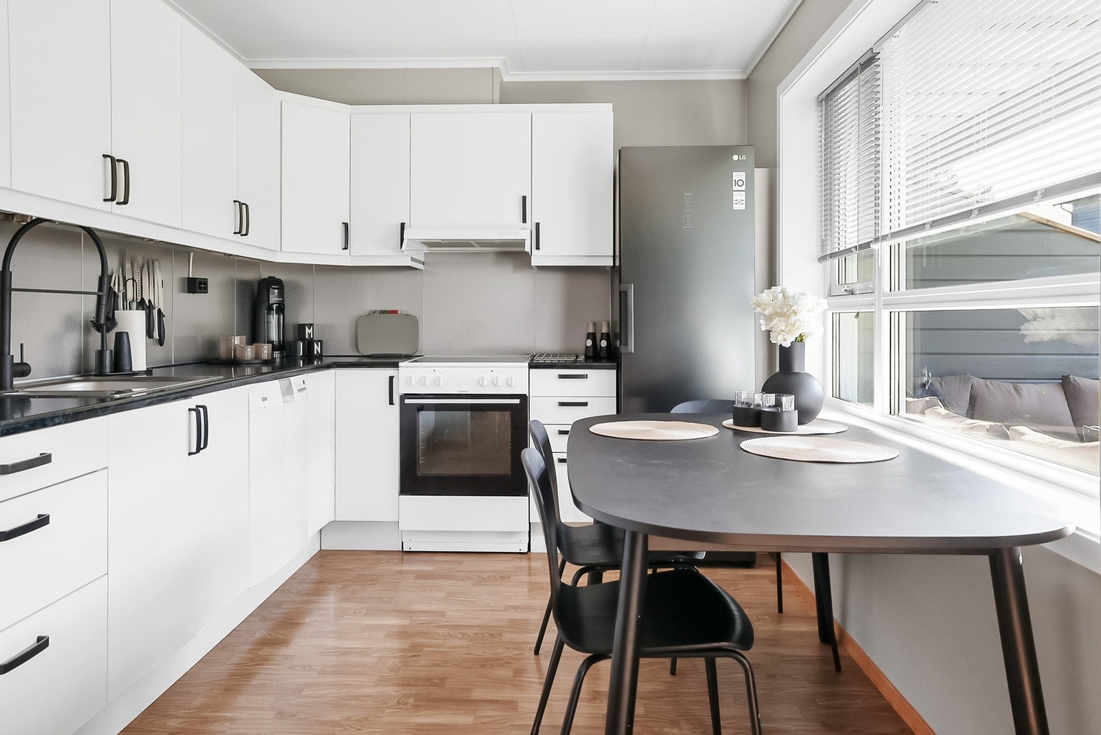 Kjøkkenet har en lys innredning med glatte fronter og benkeplate av laminat. Galleribilde