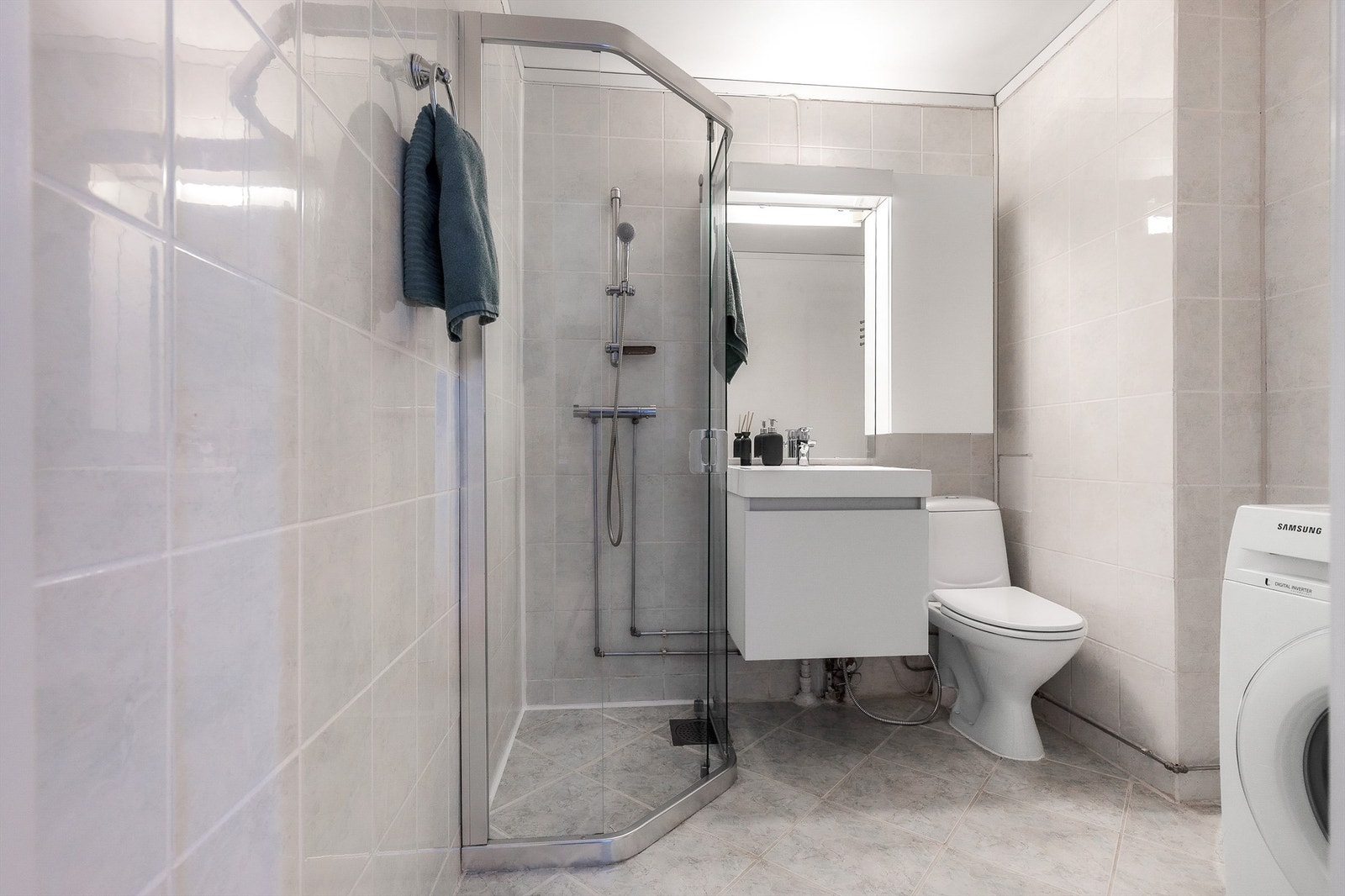Badet er pent flislagt på gulv og vegger med varme i gulvet. Innredningen består av vegghengt servantinnredning med servant. Over servanten er det et pent speil med overlys. Galleribilde