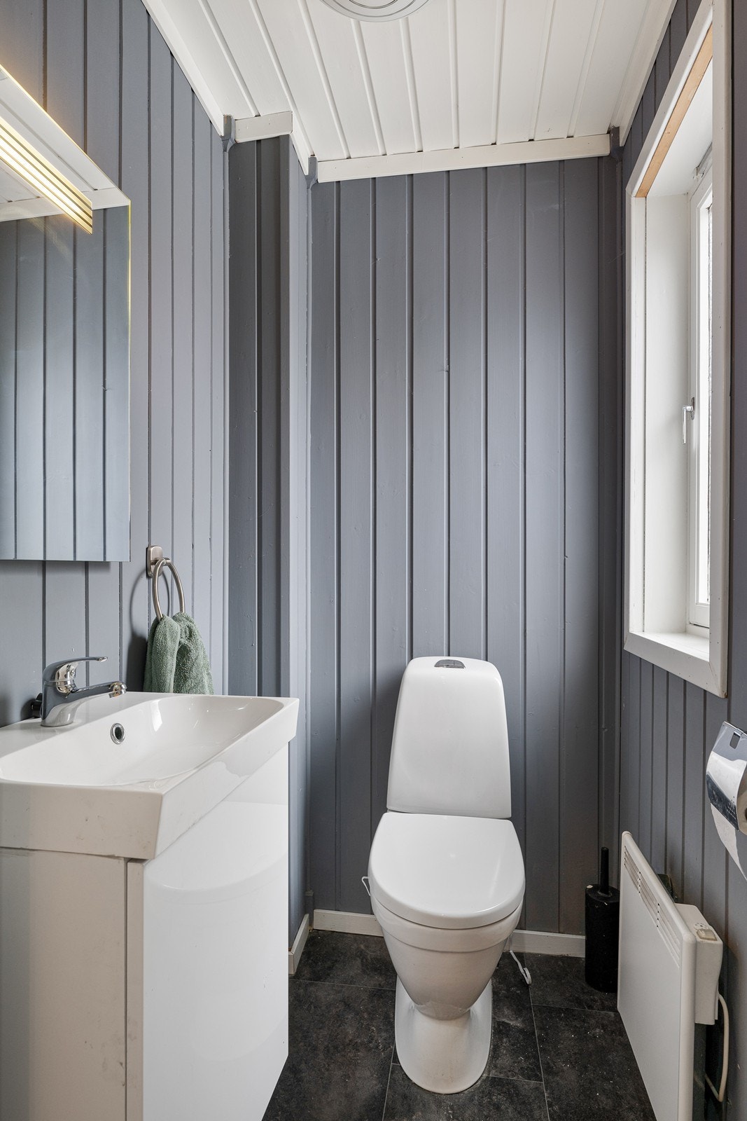 Toalettrom i 1. etasje, innredet med toalett, servant i servantskap og vegghengt speil med belysning. Galleribilde