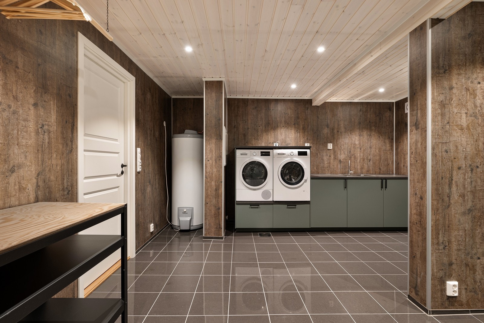 Vaskerommet er innredet med skap- og benkeinnredning med vask, opplegg for vaskemaskin og tørketrommel, vegghengt toalett og godt med garderobeskap. Galleribilde