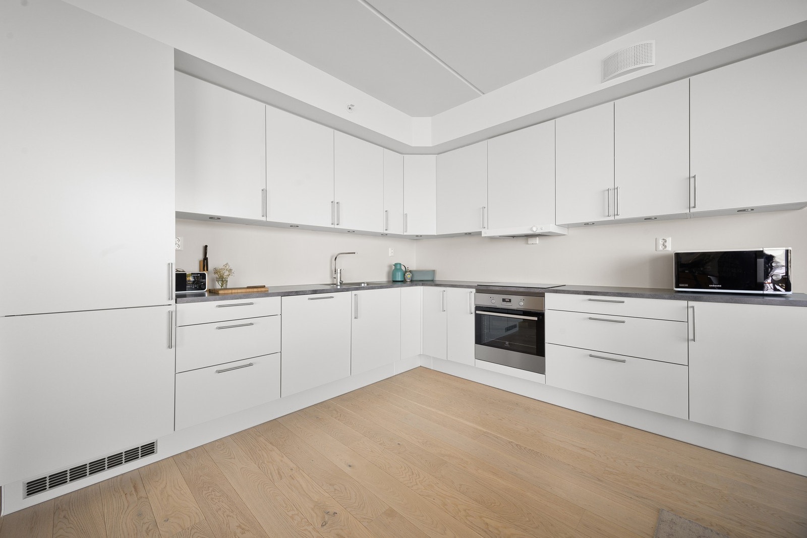 Flott, tidløs kjøkkeninnredning med glatte fronter og benkeplate av laminat Galleribilde