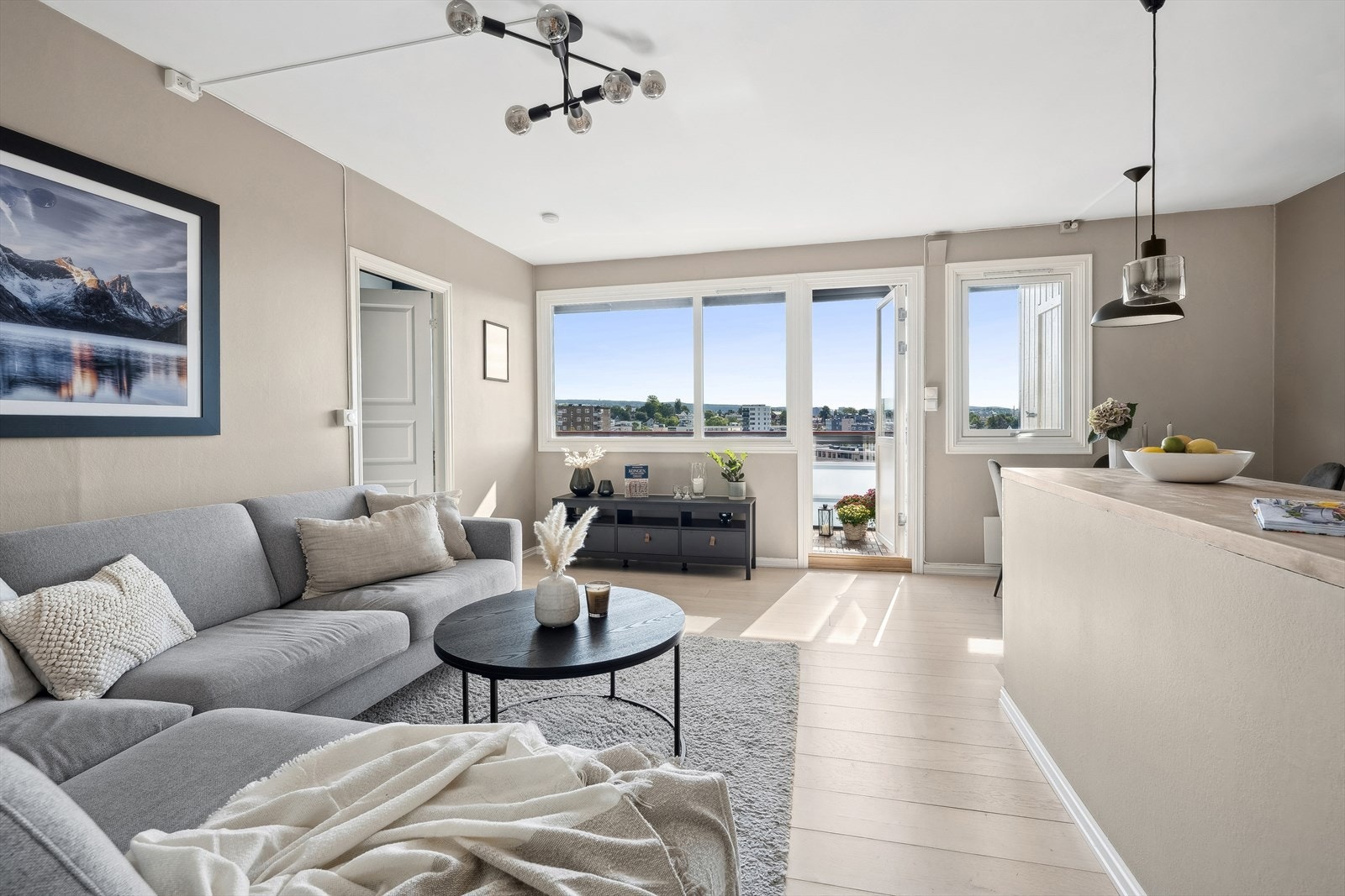 De store vindusflatene fyller leiligheten med dagslys og skaper en åpen og luftig atmosfære Galleribilde